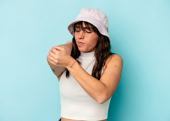 Naklejka premium Young Argentinian woman isolated on blue background massaging elbow, suffering after a bad movement.