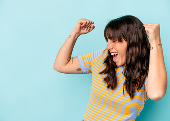 Fototapeta premium Young Argentinian woman isolated on blue background raising fist after a victory, winner concept.