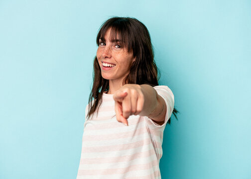 Young Argentinian woman isolated on blue background cheerful smiles pointing to front.