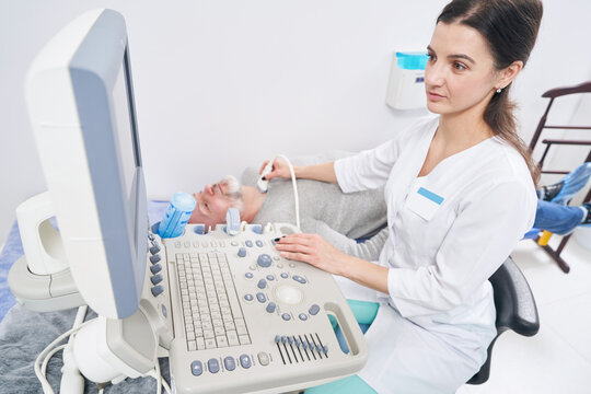 Concentrated diagnostician carrying out thyroid gland ultrasound
