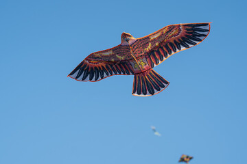 Bird kite flying against a blue sky.
