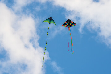 Colorful kite flying, soaring against a blue sky