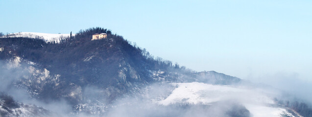Fototapeta na wymiar Horizontal banner or header with winter landscape with snow and fog in the Tosco Emiliano Apennines, Bologna, Italy