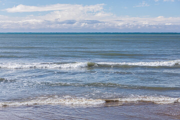 Morning bright blue skies with transparent white clouds and restless deep sea. Feeling calm, cool, relaxed.