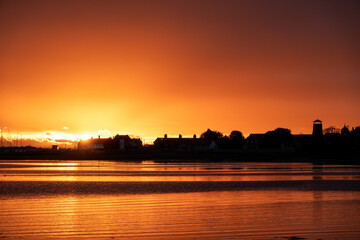Fototapeta premium vibrant orange sunset over the sea at Langstone Harbour England