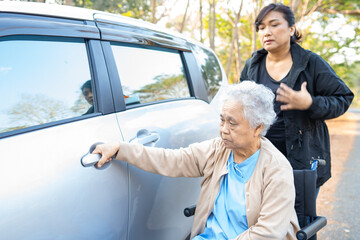 Caregiver help and support asian senior woman patient sitting on wheelchair prepare get to her car.