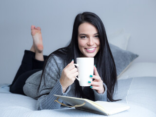 Selective focus horizontal portrait of beautiful smiling brunette young woman in grey sweater and...