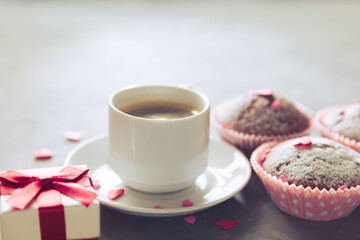 Cup of coffee, chocolate muffins and gift.