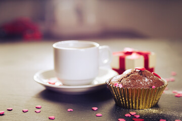 Cup of coffee, chocolate muffins and gift.