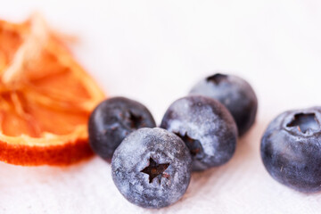  Macro of fresh blueberry and an orange on  white background. Source of nutrients and vitamins concept
