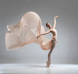 Beautiful ballerina dancing in the body color ballet leotard with body color cloth. She danced on ballet pointe shoes.