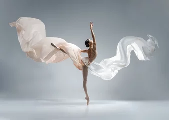 Gordijnen Mooie ballerina die danst in balletpakje in lichaamskleur met stof in lichaamskleur. Ze danste op balletschoenen. © Alina