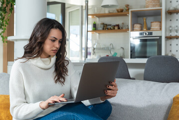 Fototapeta premium Young successful graphic designer woman sitting at home working as freelancer online marketing web developer. Female entrepreneur work on website design for online education and advertisement.