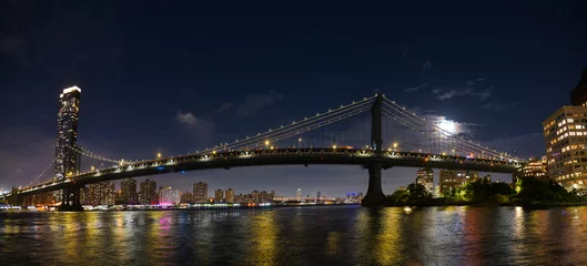 Fotobehang Manhattan Bridge onder het nachtlandschap van de volle maan. Deze verbazingwekkende constructie is een van de meest bekende bezienswaardigheden in New York. © Dragoș Asaftei