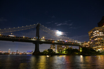 Manhattan Bridge under the full moon night landscape. This amazing constructions is one of the most...
