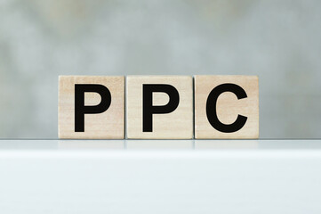 PPC text on wooden cubes on a light table in isolation, business concept