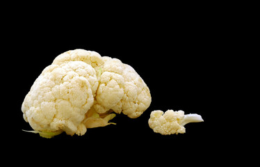 Fresh cauliflower vegetable stands on a black background. Selective focus. Space for text. Healthy...