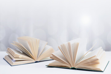 Abstract background - two open books, glare of light and bokeh.