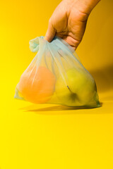  Fruit lies in a reusable bag for shopping on a yellow background. Vertical photo. High quality photo
