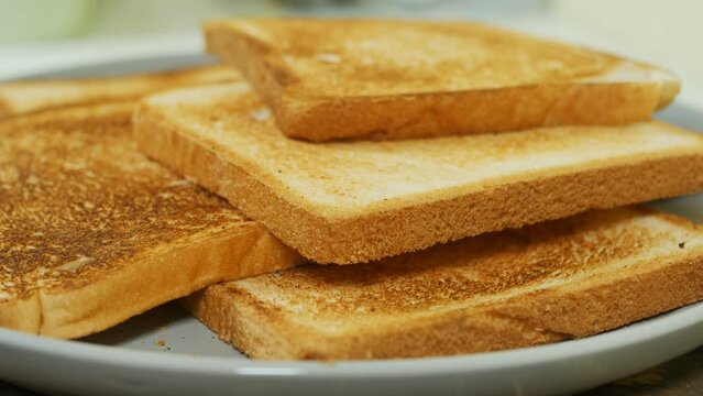 crispy golden white bread toasts in a bowl close-up rotate