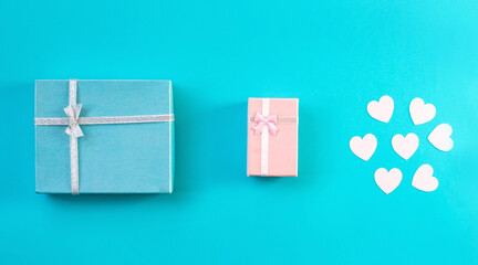 Gift boxes with ribbon and red heart, blue background.