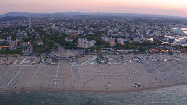 4k drone flight back footage (Ultra High Definition) of Libera Rimini public beach. Wonderful summer scene of Italy, Europe. Superb evening view of Adriatic coast. Traveling concept background..