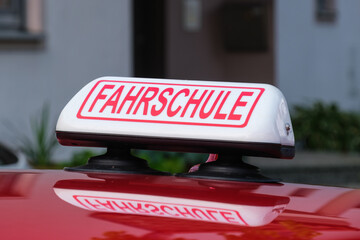 Fahrschule - Schild / Kennzeichnung auf einem roten Fahrschulauto