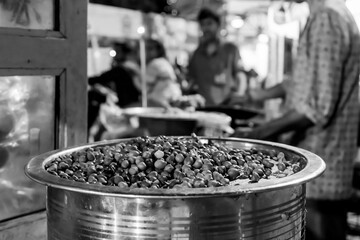 Chana or chola or matar for preparing ghugni and chotpoti, delicate Indian Bengali famous street food dihes, are stored for preparation. Gajan festival at Howrah, West Bengal, India. Black and white.