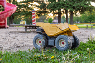 Old rusty toy truck abandoned or forgotten in the park playground