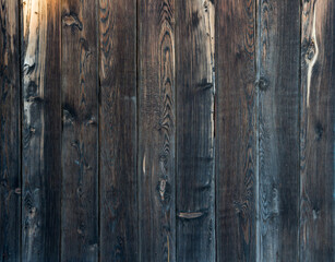 Plank fence made of dark old wood. Natural wood pattern. Surface fragment