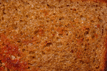 The surface of bread fried in butter with a crispy crust. Close-up texture