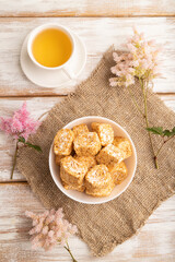 Fototapeta premium Traditional turkish delight (rahat lokum) with cup of green tea on a white wooden background. top view, close up.