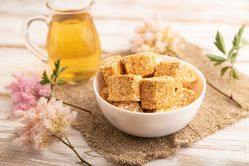 Traditional turkish delight (rahat lokum) with glass of green tea on a white wooden background. side view, close up.