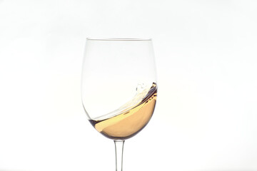 glass of white wine splashing on white background
