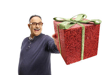 Happy mature casual man showing a present in front of camera