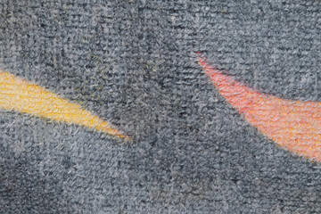 Close up rug with yellow and orange lines on black backdrop