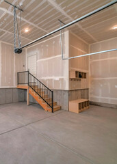 Vertical Interior of an unfinished garage with staircase leading to the door