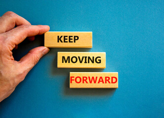 Keep moving forward symbol. Concept words Keep moving forward on blocks on beautiful blue table blue background. Businessman hand. Business, motivation and keep moving forward concept. Copy space.