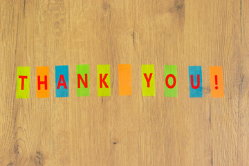 Thank you symbol. Concept words Thank you on colored papers on a beautiful wooden background. Business and thank you concept, copy space.