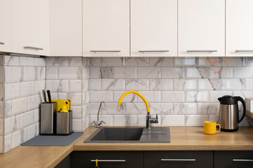 Modern and stylish white and grey kitchen with yellow accents