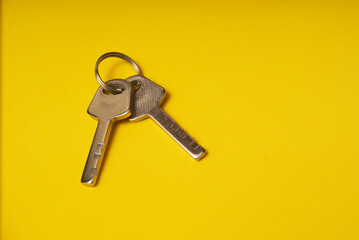 Two keys on a yellow background top view