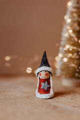 Weihnachten, Weihnachtsfest - Fröhlich lächelnde Weihnachtsfigur steht vor Weihnachtsbaum aus Draht 