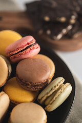 Bakery Still Life. Pastel Macarons. Multicolored Macarons with Dark Chocolate Bark in Background. Macaron Flat Lay with Copy Space.