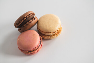Bakery Still Life. Pastel Macarons. Vanilla, Chocolate, and Strawberry Macarons Stacked on White Background. Isolated Macarons.