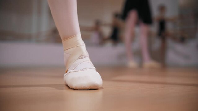 Ballet training - little girls stands on the pointe shoes