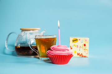 Birhtday cupcake with cup of tea and present box. Drink teaa with sweets.