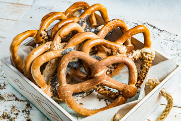 Fresh prepared homemade soft pretzels. Different types of baked bagels with seeds on a black background.