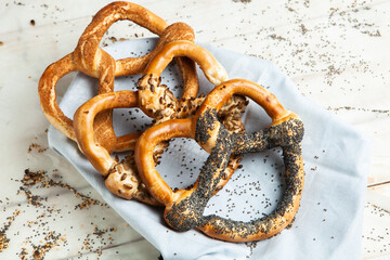 Fresh prepared homemade soft pretzels. Different types of baked bagels with seeds on a black background.