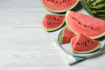 Tasty ripe watermelons on white wooden table, space for text