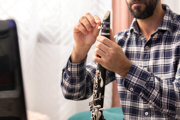 Clarinetist giving online clarinet class with the laptop from ho